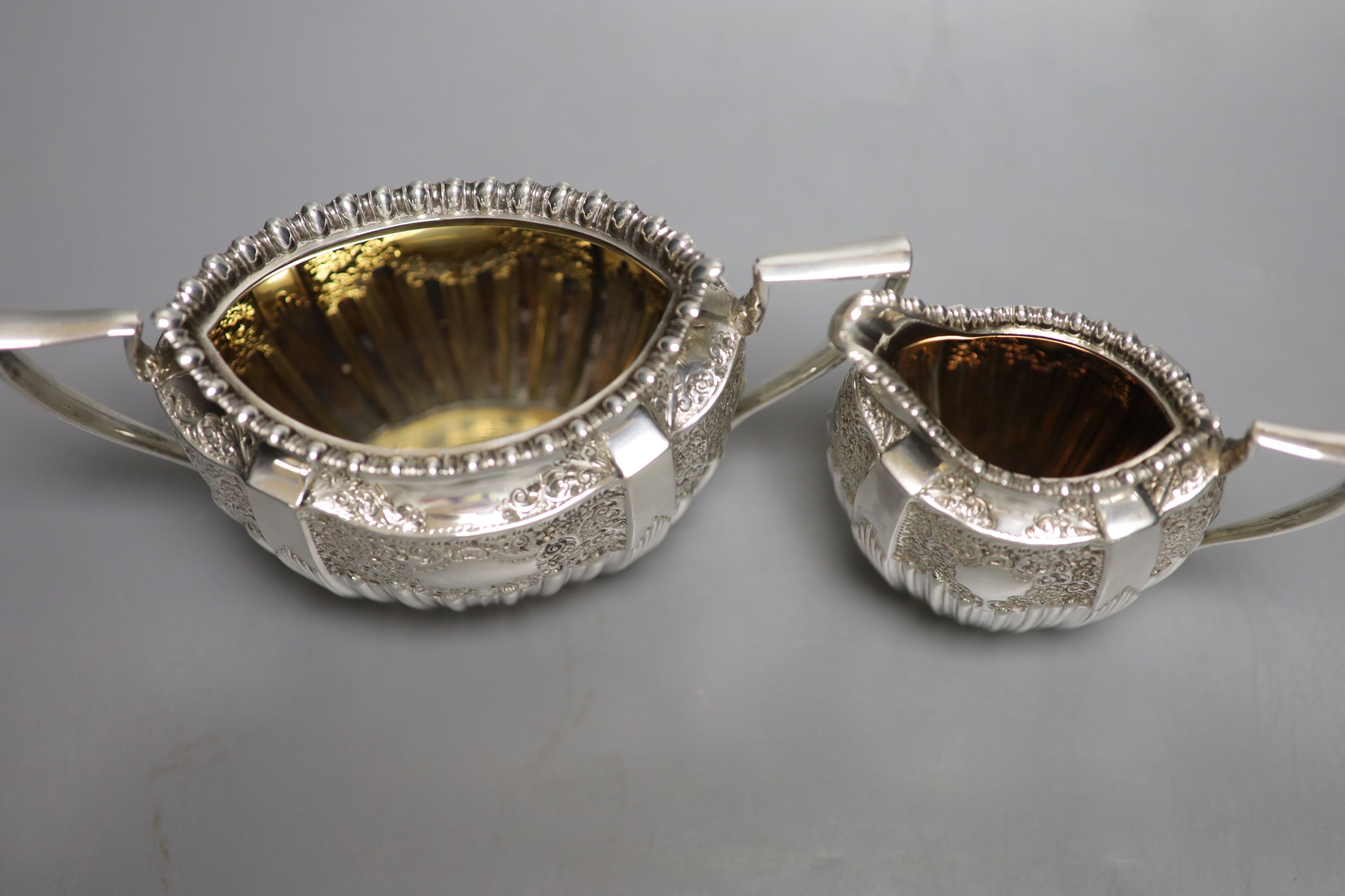 A late Victorian embossed silver sugar bowl and cream jug, James Dixon & Sons, Sheffield, 1896/7,